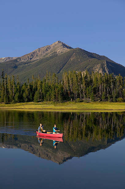 istock Couple Canoeing on Mountain Lake 115938988