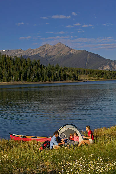 istock Family Camping on Mountain Lake with Canoe 115939009