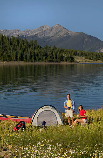 istock Couple Drinking Coffee at Mountain Lakeside Camp Site 115939011