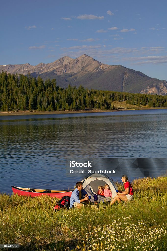 Famiglia campeggio con canoa sul lago di montagna - Foto stock royalty-free di Bambino