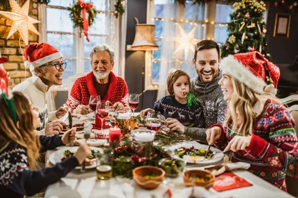 Photo of Happy extended family having New Year's lunch at dining table.