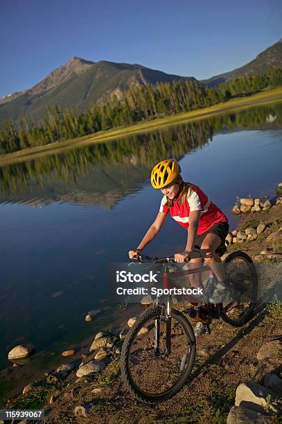 Dziewczyna Jazda Na Rowerze Przez Mountain Lake - zdjęcia stockowe i więcej obrazów Bicykl - Bicykl, Czerwony, Czynność
