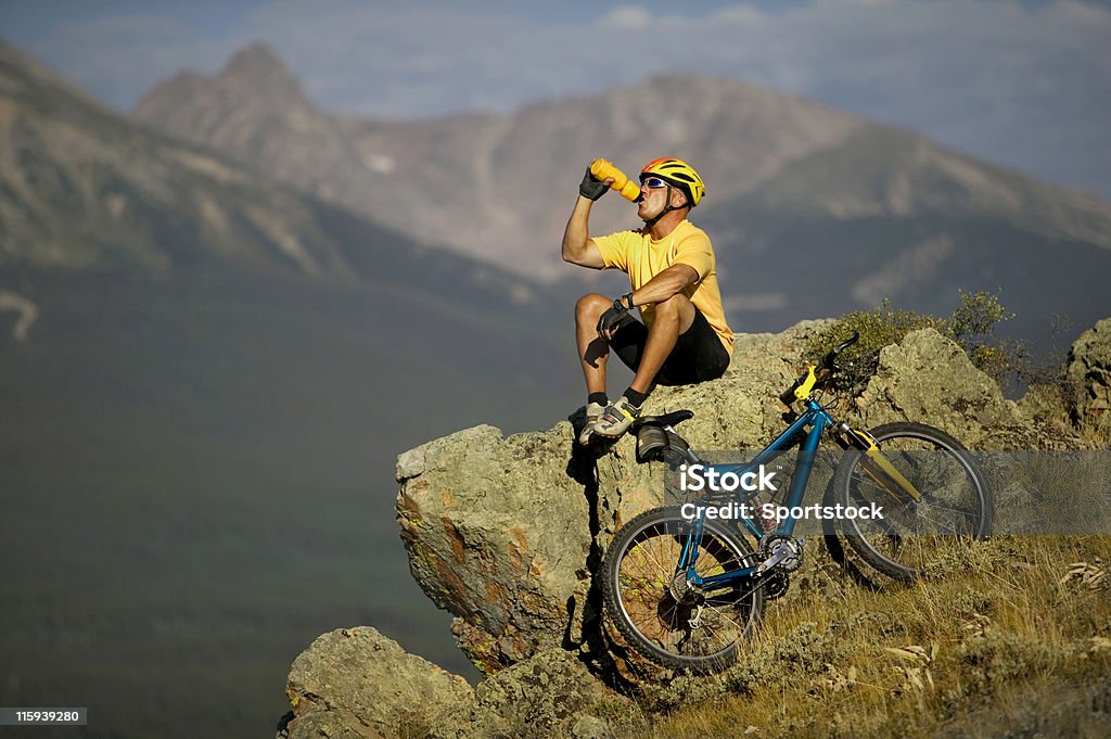 Motocyklista w góry pije z butelki z wodą - Zbiór zdjęć royalty-free (Pić)