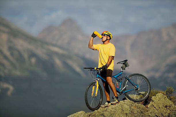пить из бутылки с водой на велосипеде в горах - mountain biking colorado action cycling стоковые фото и изображения