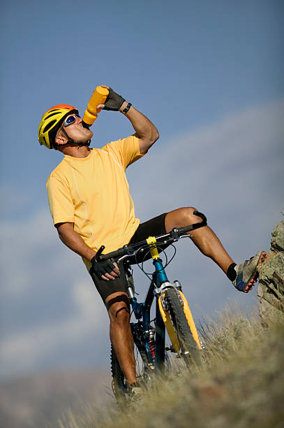 мужчина на велосипеде пить из бутылки с водой - mountain biking colorado action cycling стоковые фото и изображения