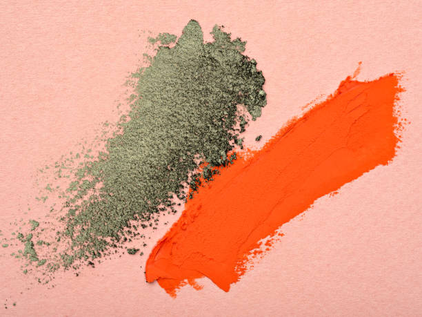 abstriche von orangefarbenem lippenstift und grünem lidschatten. - green eyeshadow stock-fotos und bilder