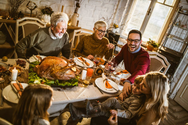istock Happy extended family having fun during Thanksgiving meal at dining table. 1159393462