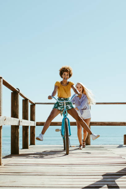 due ragazze che si divertono durante le loro vacanze - bicycle ride foto e immagini stock