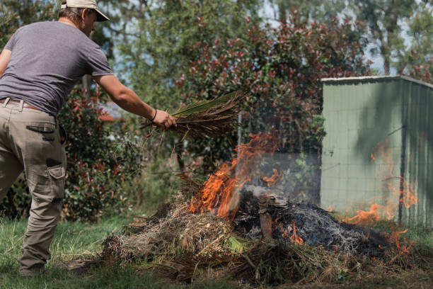 istock Man tending to fire controlled burn off of garden waste 1159394341
