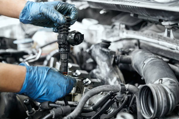 istock Male specialist replacing ignition coil and old nozzles 1159394584