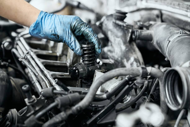 istock Professional mechanic checking nozzle in diesel car engine 1159394593
