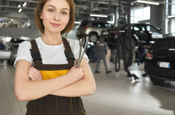 istock Young female mechanic keeping wrench and looking at camera 1159394647