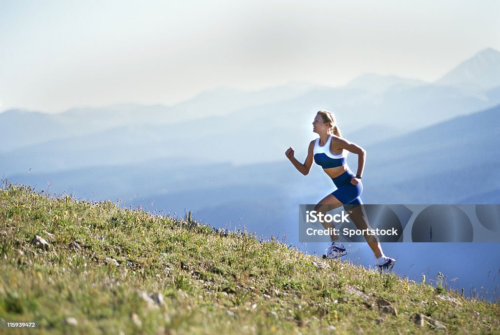 Bella donna in esecuzione su Mountain - Foto stock royalty-free di Corsa veloce