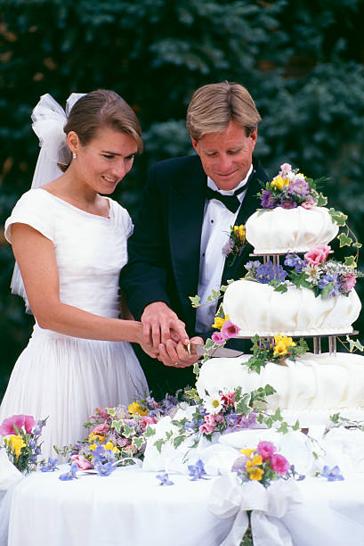 istock Bride and Groom Cutting Wedding Cake 115939485