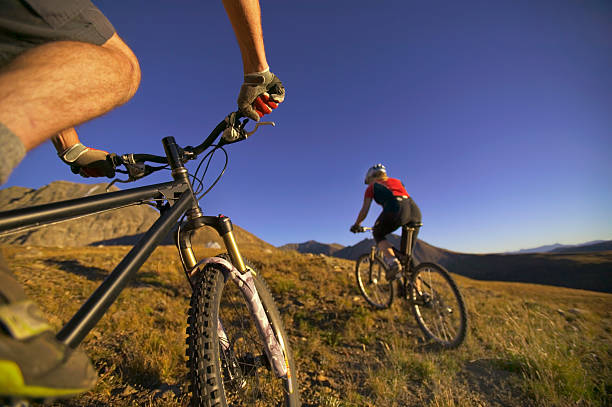 A fit mature couple out for a mountain bike ride in the countryside - Copyspace