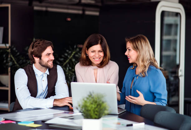 istock A group of business people sitting in an office, using laptop. 1159397023