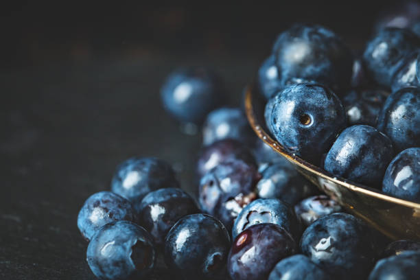 istock Juicy and fresh blueberries with green leaves on rustic table. Blueberry antioxidant. Concept for healthy eating and nutrition. Selective focus. 1159397384