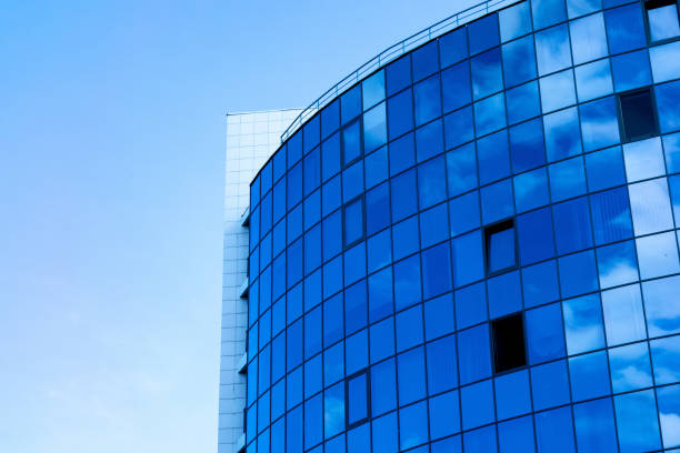 istock Glass wall facade with cloud sky reflection. Modern urban architecture background. Skyscraper business center, bank or hotel in city downtown. Glassy megalopolis exterior 1159399196