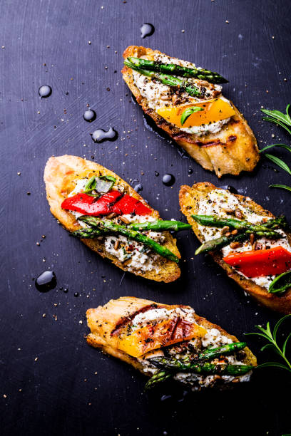 istock Toasts (sandwiches) with cheese, pepper and asparagus on black 1159400772