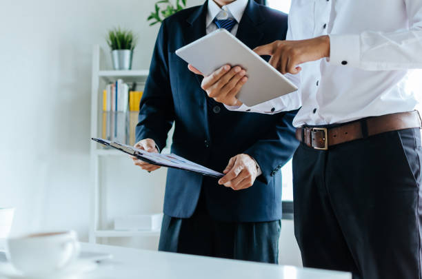 istock Job training. new manager boss mentor standing teaching online work with mobile tablet to young intern apprentice learning statistics chart, working at office, internship, practicum, trainee concept 1159401918