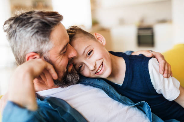 istock Mature father with small son sitting on sofa indoors, resting. 1159402078