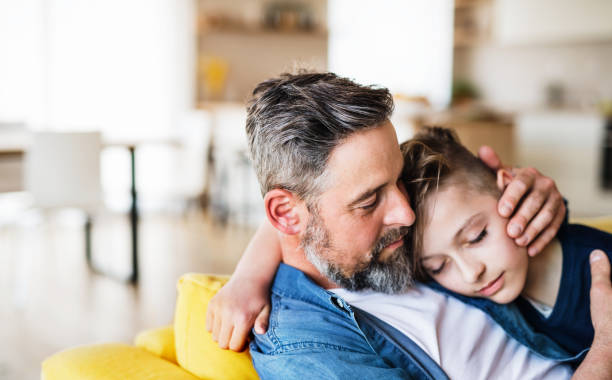 istock Mature father with small son sitting on sofa indoors, resting. 1159402085
