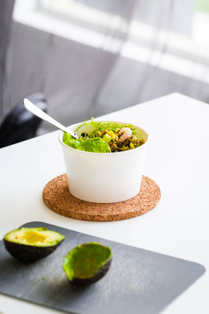 Green salad to go in white paper bowl