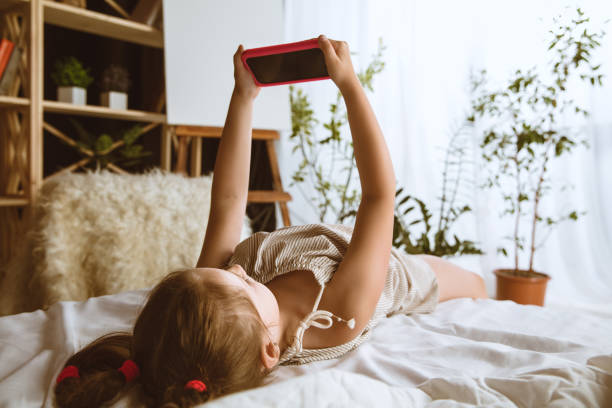 istock Little girl using different gadgets at home 1159405468
