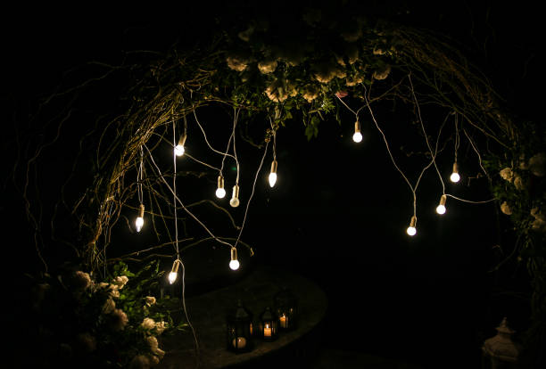 istock White flowers arch at the wedding ceremony. Outdoors decoration. Romantic rustic style. Lamps lights in the evening. 1159406698