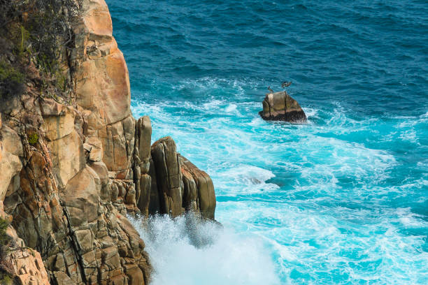 istock Blue sea with rocky shore in sunny afternoon 1159409338