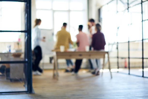 istock Back view of people silhouette collaborating on building project.Blurred focus on talented male and female students team working on training task sitting in university studio during brainstorming 1159411309