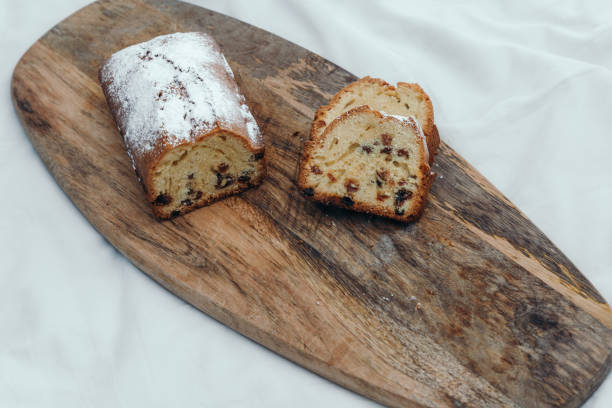istock Raisin cake, dusted with icing sugar. Cupcake with raisins on a wooden board. 1159412250