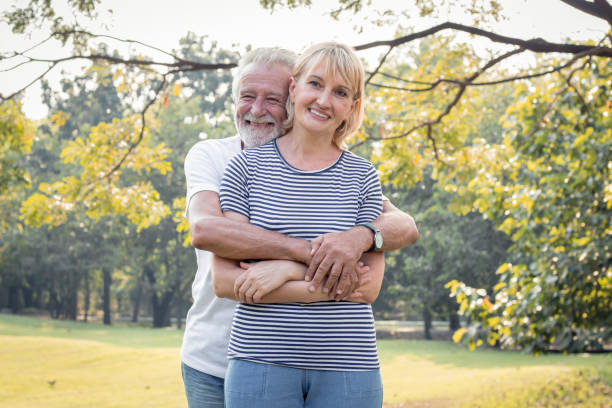 istock Senior couples stand to hug each other and smile happily. 1159412974