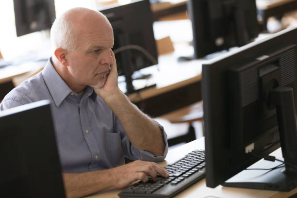 istock Thoughtful businessman staring at desktop monitor 1159413150