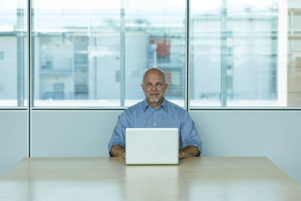 istock Senior businessman with laptop in office 1159413166