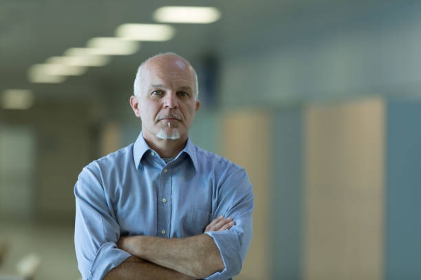 istock Senior businessman with folded arms indoors 1159414146