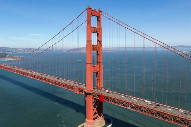 Aerial view of the Golden Gate Bridge tower with San Francisco Bay in background.