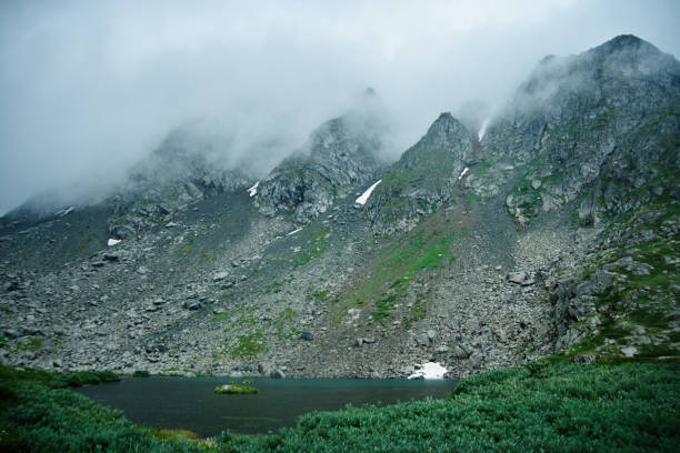 istock Mountain landscape. Lake, rocky mountains and clouds 1159414773