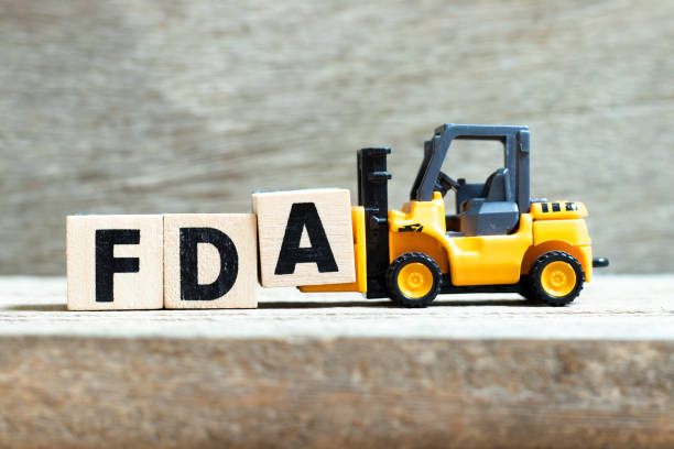 Toy forklift hold letter block A to complete word FDA (abbreviation of food and drug administration) on wood background Toy forklift hold letter block A to complete word FDA (abbreviation of food and drug administration) on wood background food and drug administration stock pictures, royalty-free photos & images