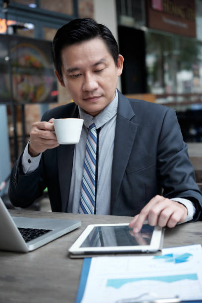 istock Businessman drinking coffee and reading news online 1159416490