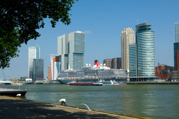 Rotterdam, Netherlands - June 26, 2019: The new harbor district of Rotterdam (Kop van Zuid) located on the south bank of the Nieuwe Maas, opposite to the city center of Rotterdam. Cruise ship Queen Victoria anchors at the Kop van Zuid pier.
