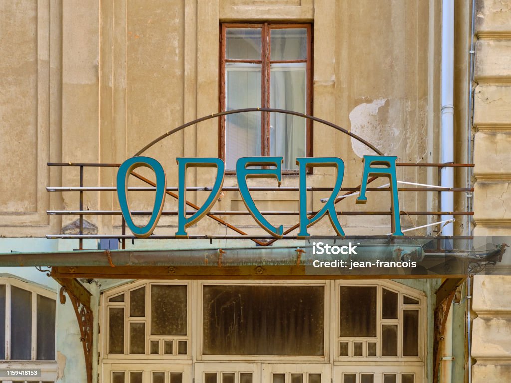 "Opera" sign on abandoned building. r Art Nouveau antique "Opera" sign on abandoned building.  Focus on the falling apart sign on top ruins of the door Retro Style Stock Photo