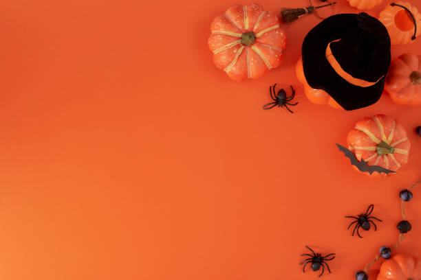 istock Pumpkins decorations on orange paper background. Halloween concept 1159418484
