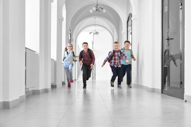 istock Pupils playing together and running on school corridor. 1159419930