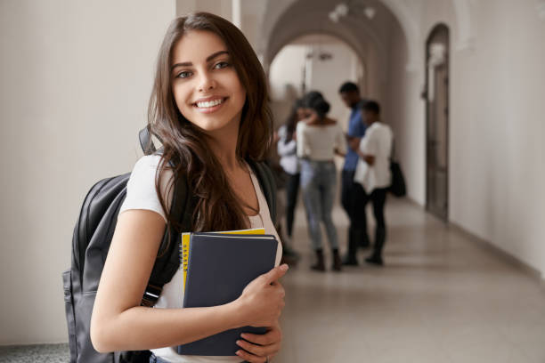 ノートとバックパックを持つブルネットの女子学生。 - university classroom campus student ストックフォトと画像