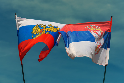 Russian and Serbian flag tied together as symbol of cooperation between two countries