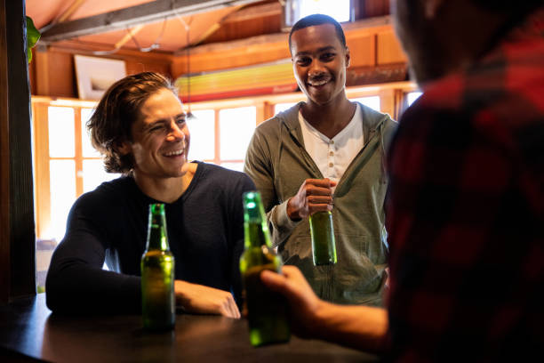 istock Male friends having fun at home drinking beers 1159421994