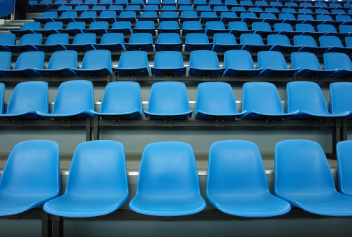 Blue stadium chairs in an empty stadium
