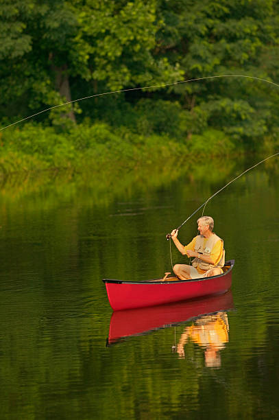 istock Senior Man Fly Fishing From Canoe 115942223