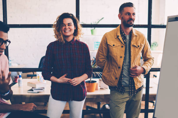 istock Cheerful female team member satisfied with successful project sharing idea with colleague, happy hipster girl enjoying working process in collaboration with students group making solutions together 1159423462